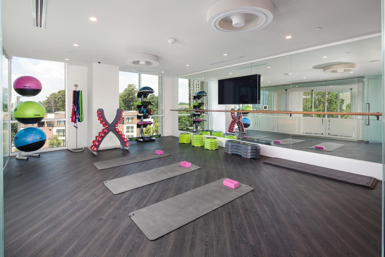 Modern fitness studio with mats and equipment.