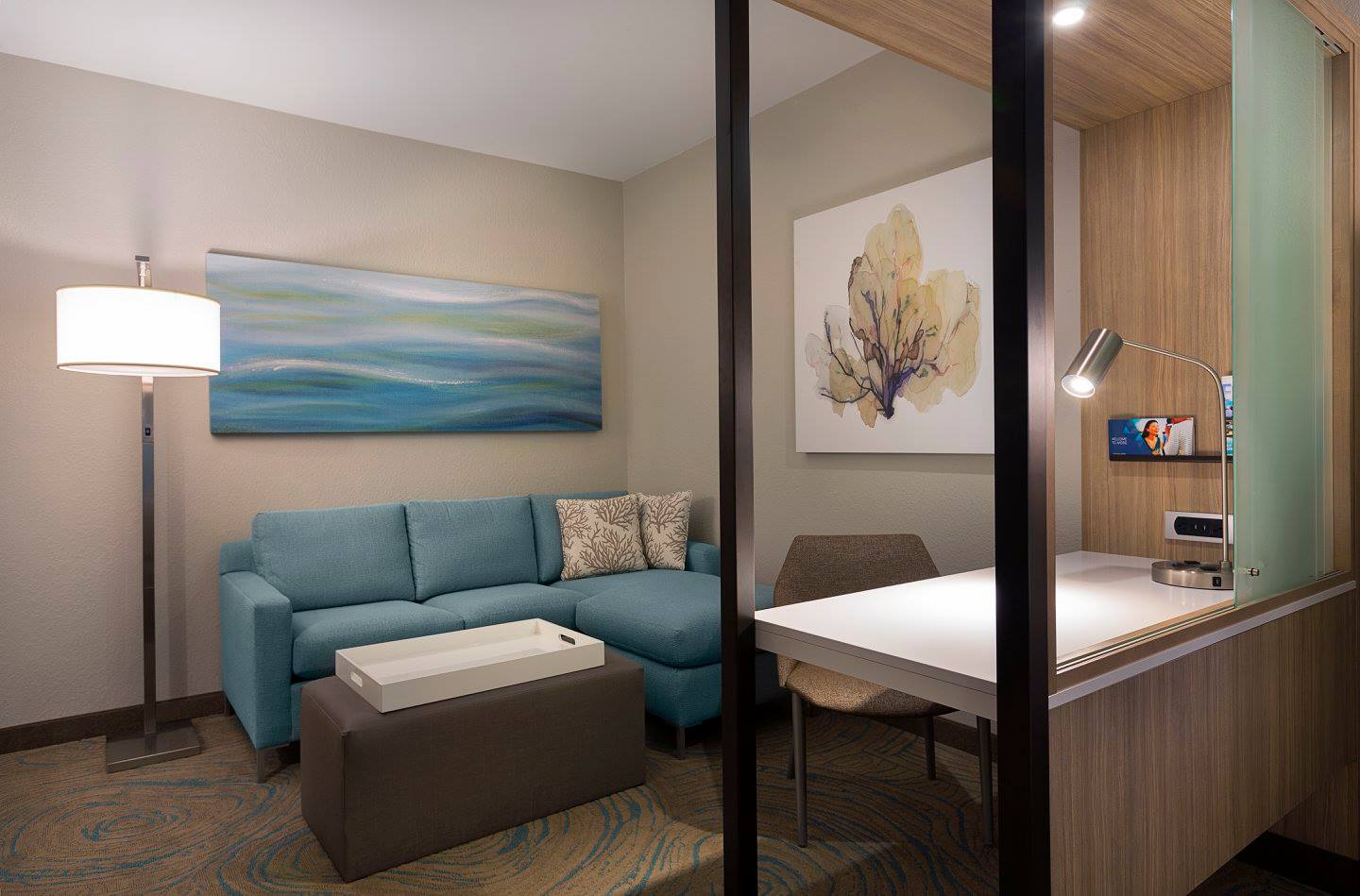 Modern hotel room with blue sofa.