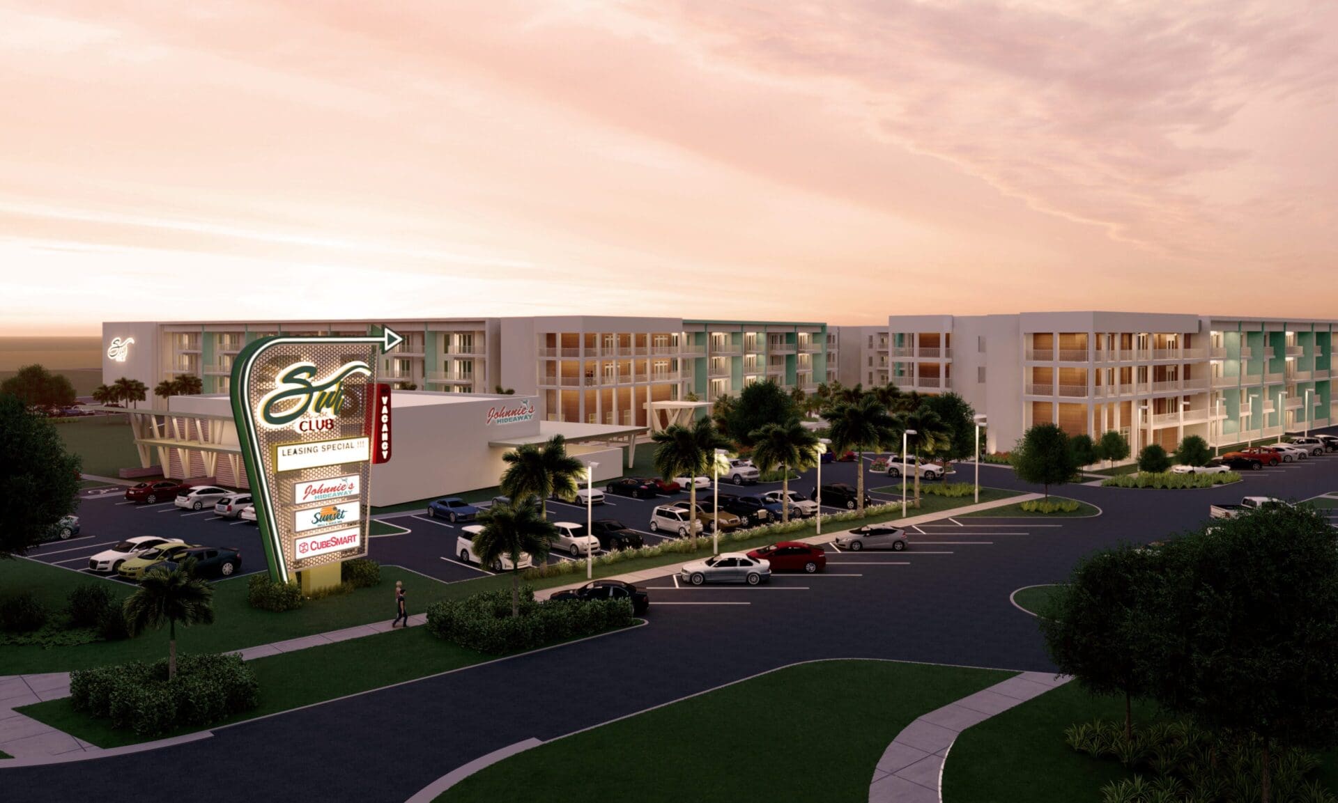 Modern hotel building with parking lot at sunset.