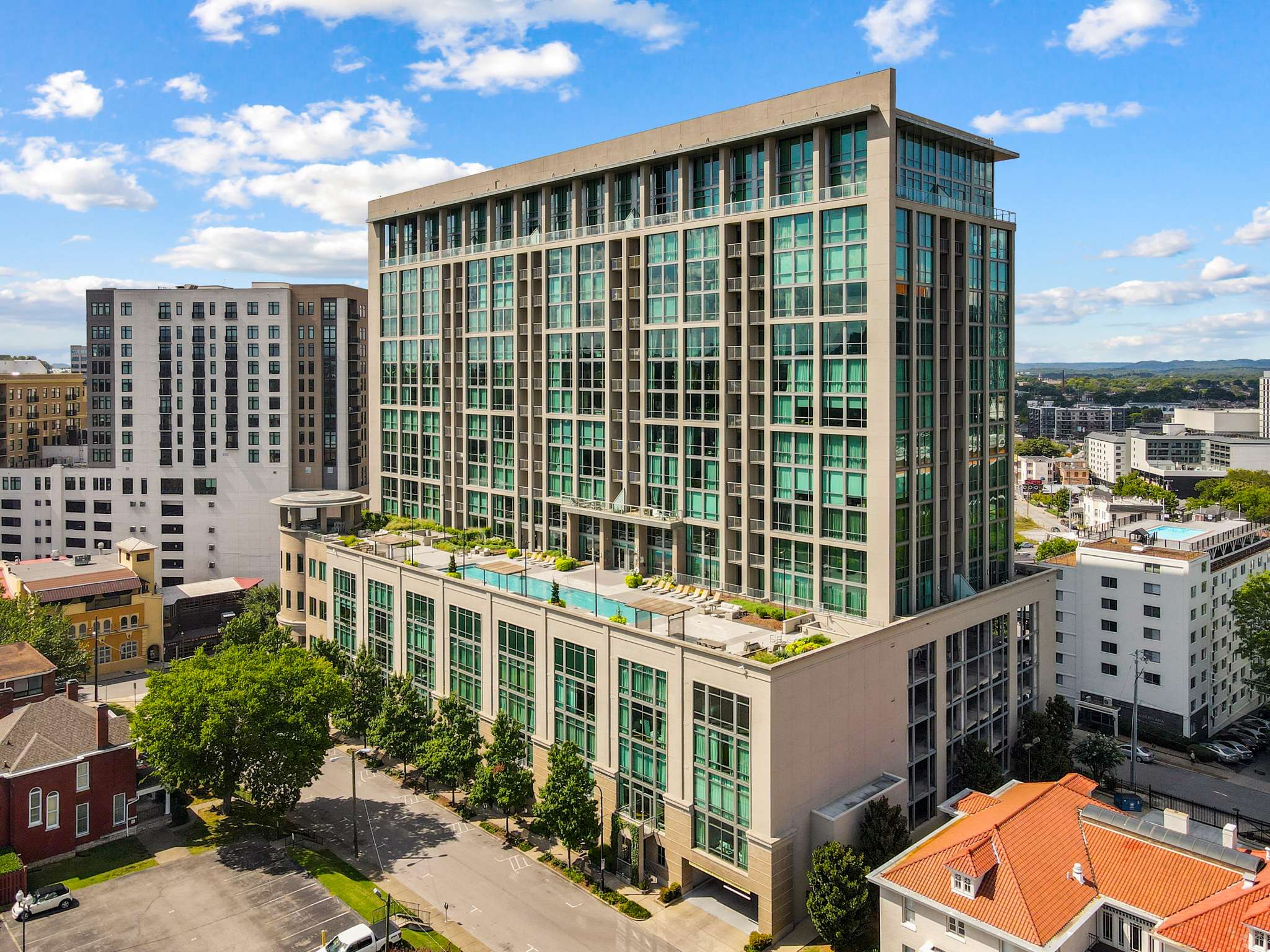 Modern high-rise building with rooftop pool.