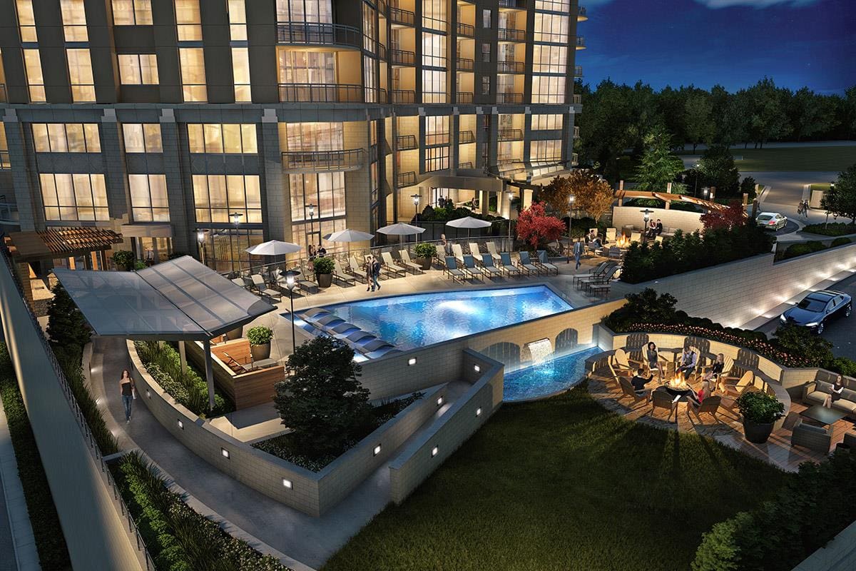 Luxury apartment complex with illuminated outdoor pool.