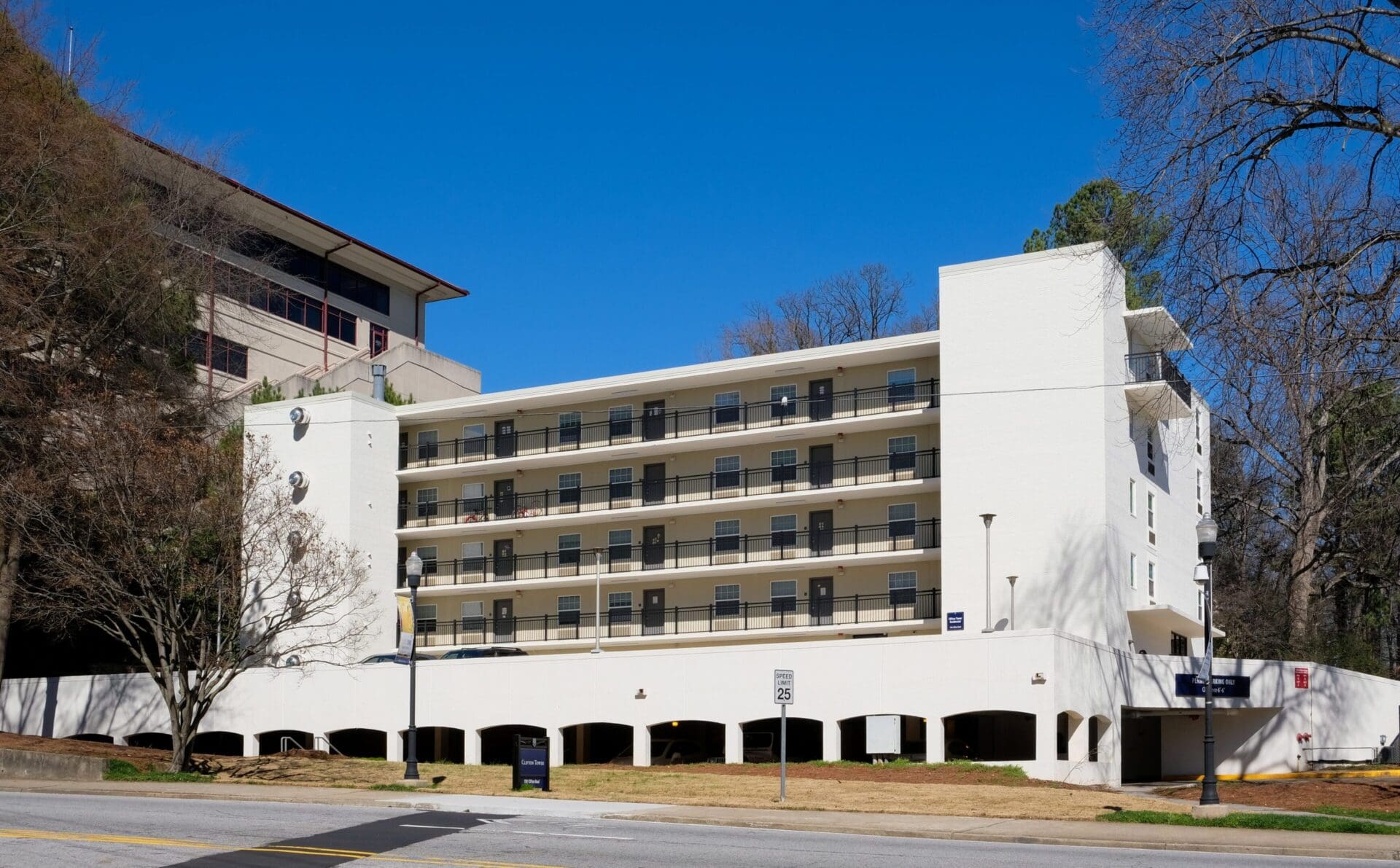 White multi-story building with balconies, sunny day.