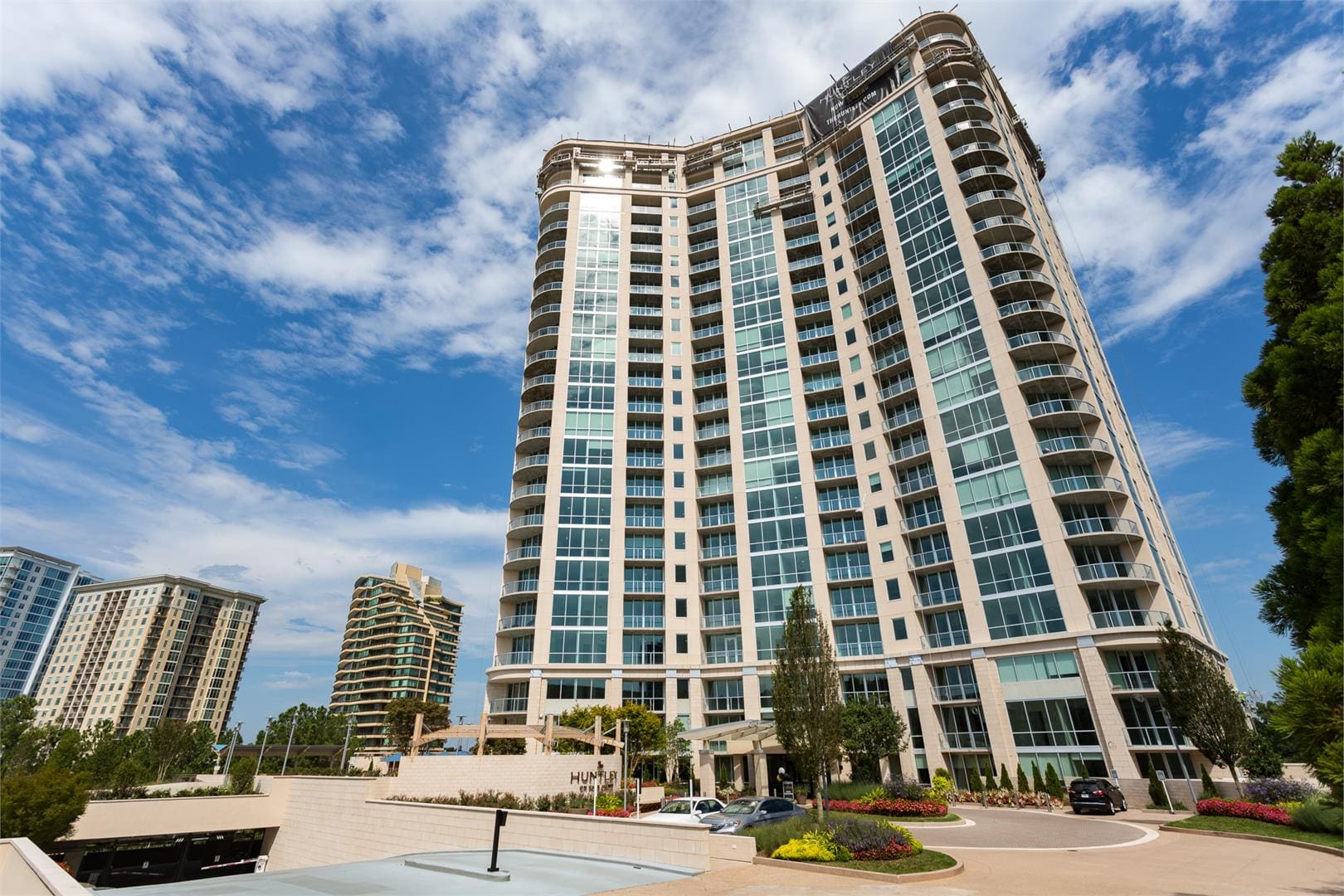 Tall modern residential building under blue sky.