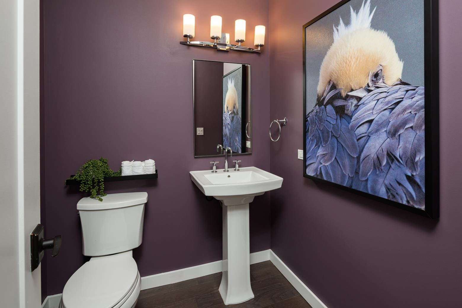 Purple bathroom with artwork and modern fixtures.