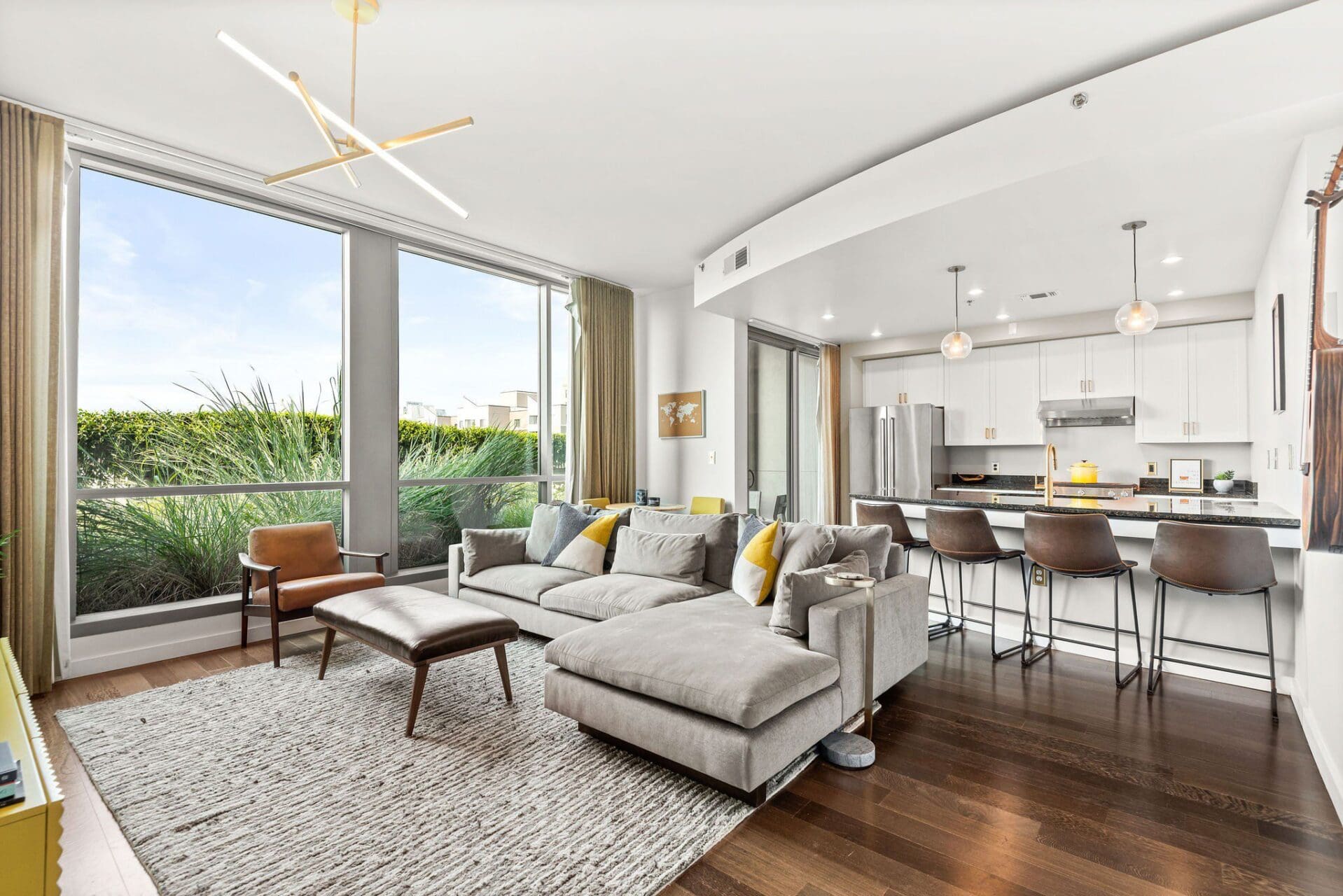 Bright living room with gray sectional and kitchen