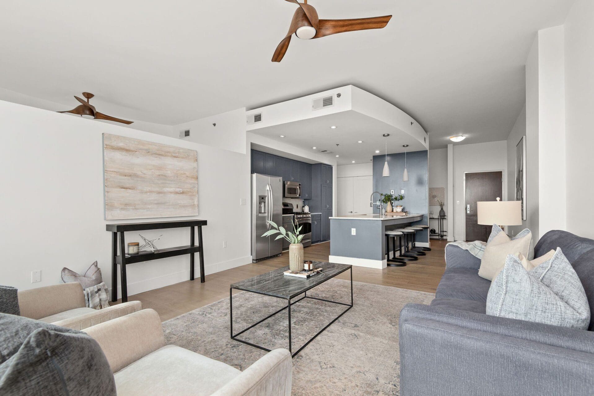 Open-plan modern living room with blue kitchen