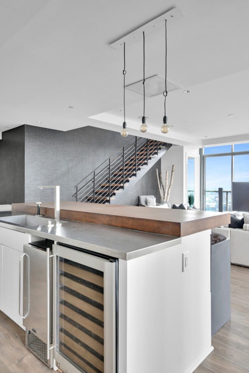 Modern kitchen with staircase and ocean view.