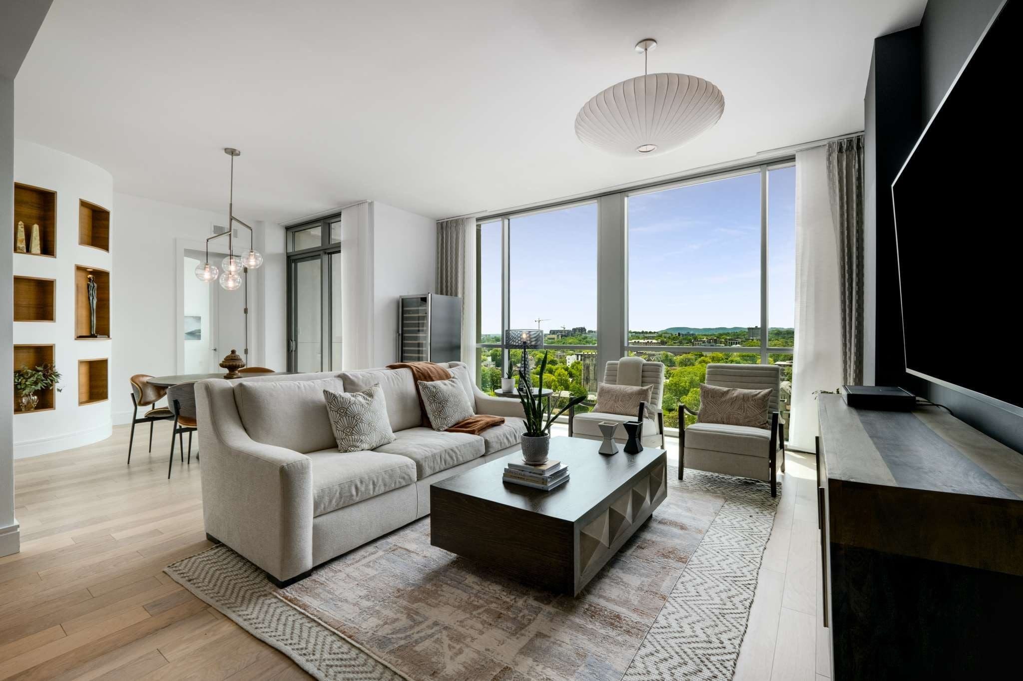 Modern living room with large windows, sofa.