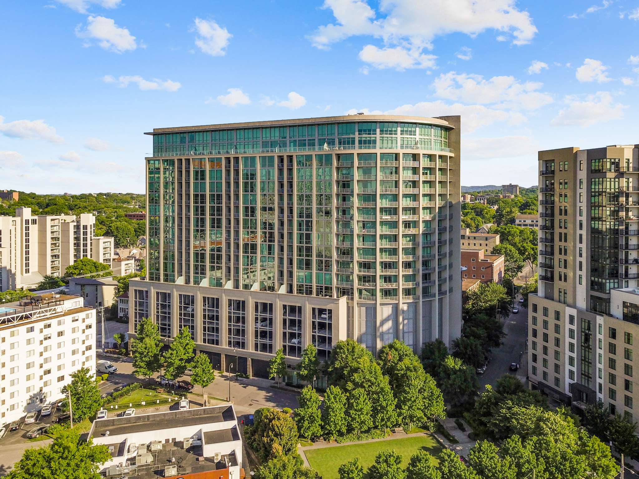 Glass-fronted residential high-rise near park