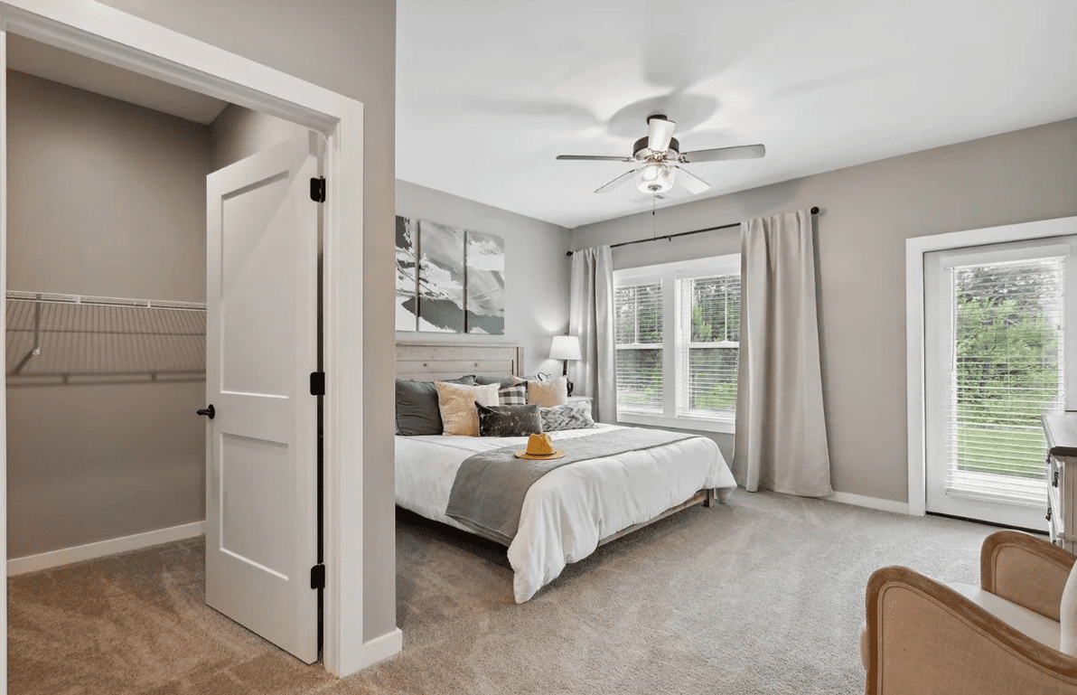 Modern bedroom with large windows and closet.