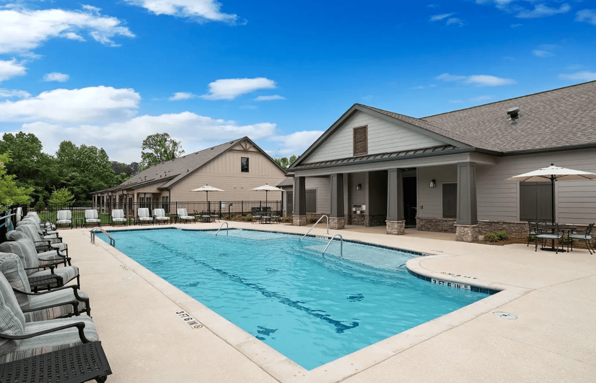 Outdoor swimming pool beside residential buildings.