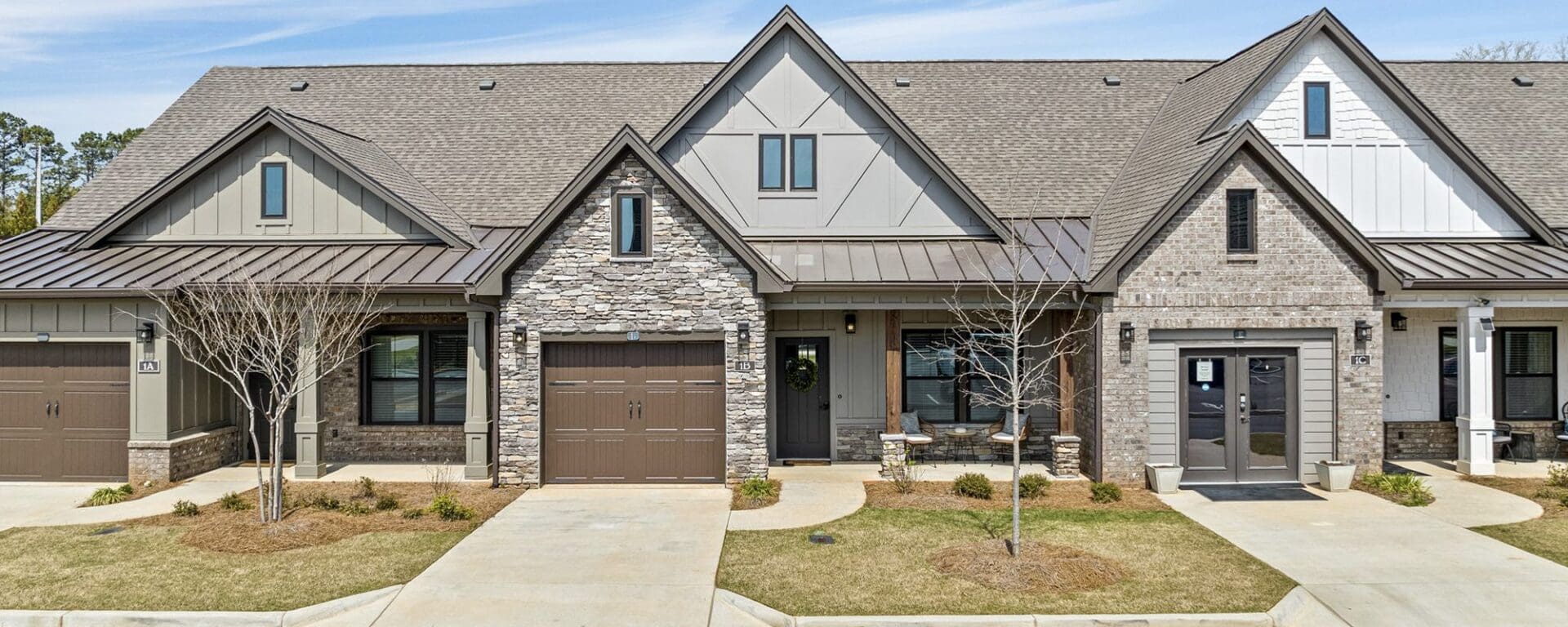 Modern townhouses with stone facades and garages.