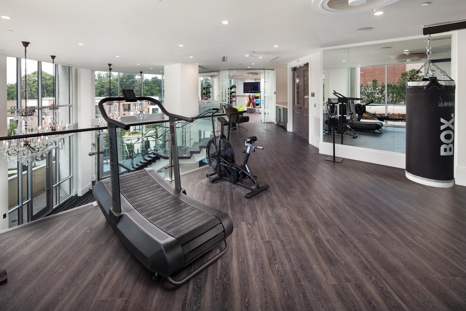 Modern gym with treadmill and punching bag.