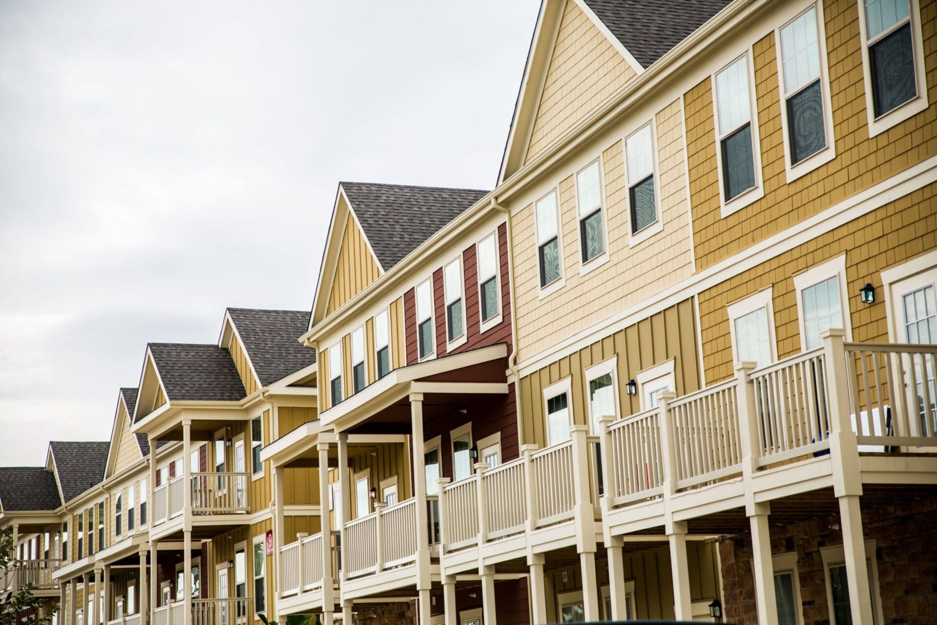 Row of colorful townhouses with porches.