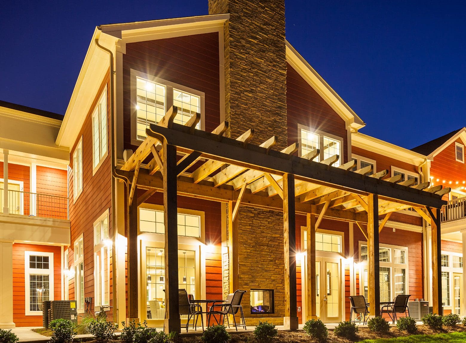 Modern house with illuminated patio at night.