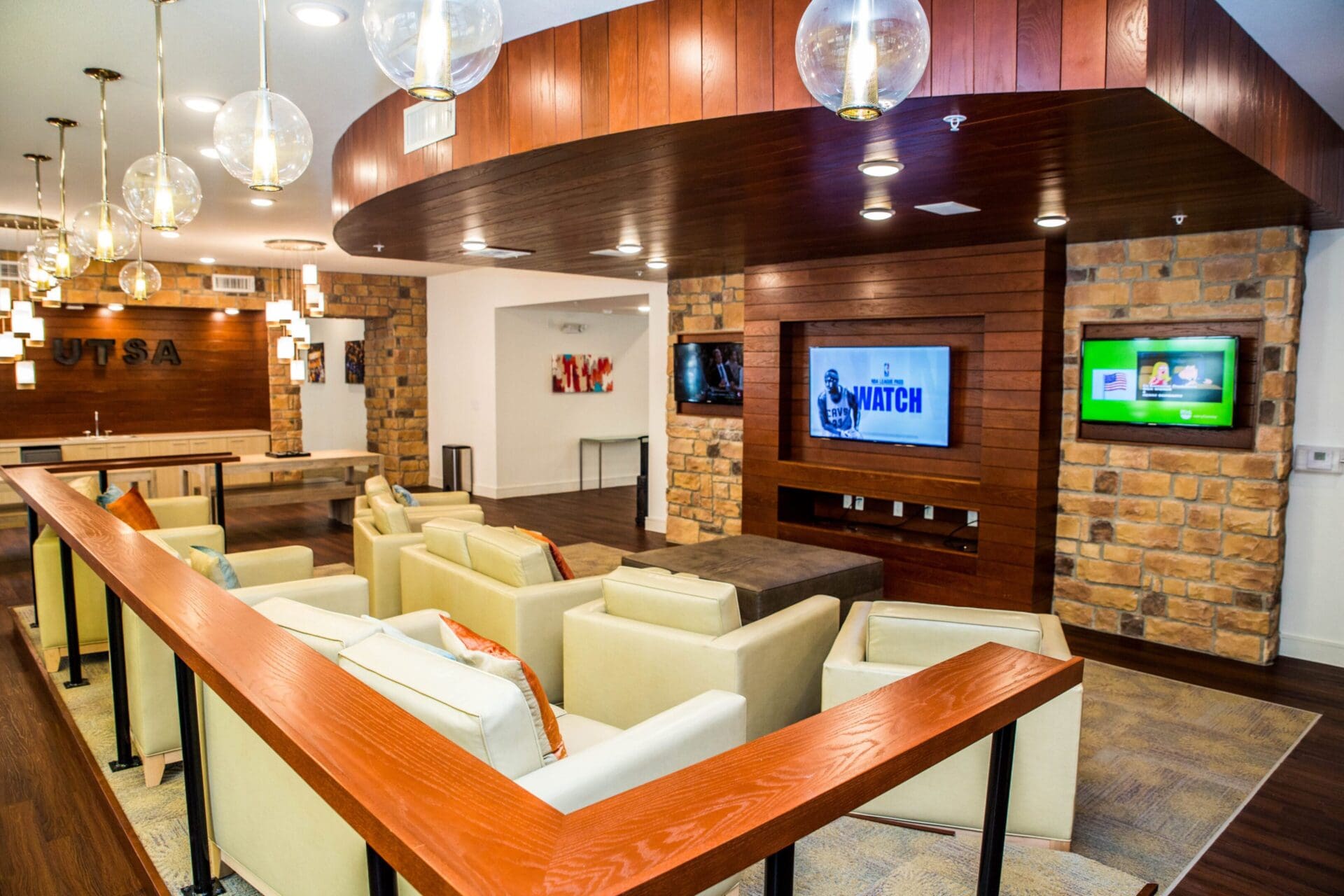 Modern lounge area with seating and screens.