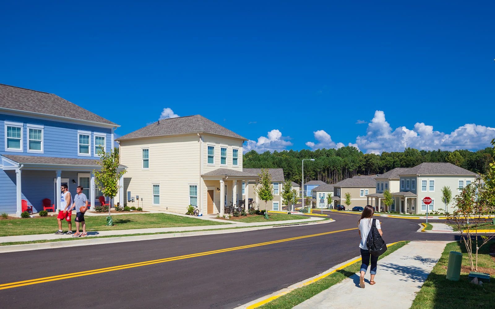 Suburban street with people and houses.