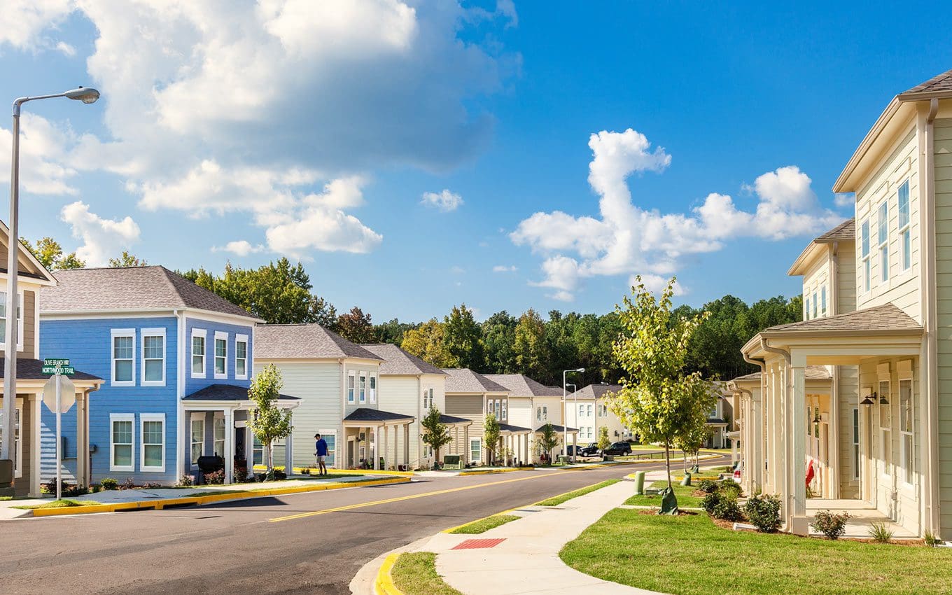 Suburban street with colorful houses and trees.