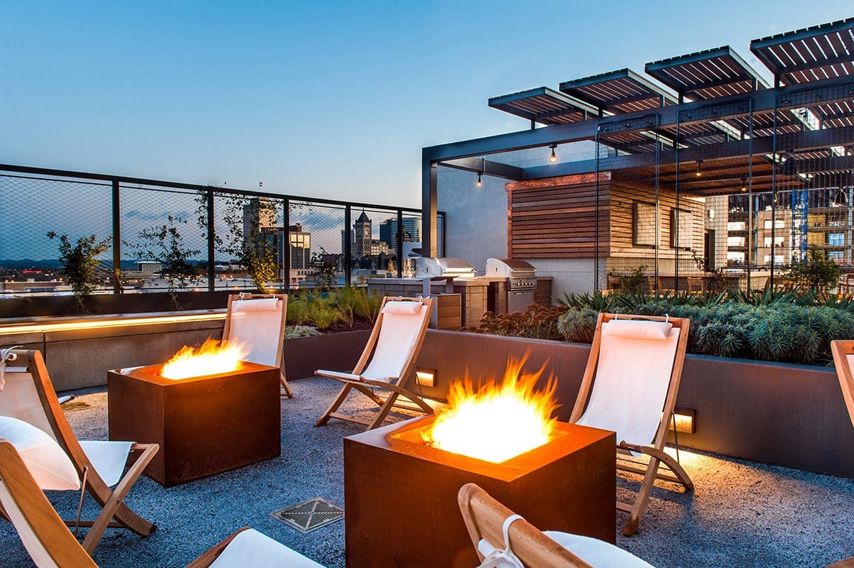 Rooftop patio with fire pits and chairs.