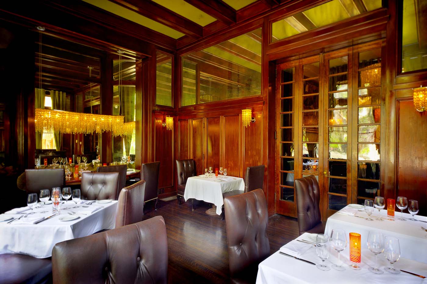 Elegant restaurant with wooden interior and chandeliers.