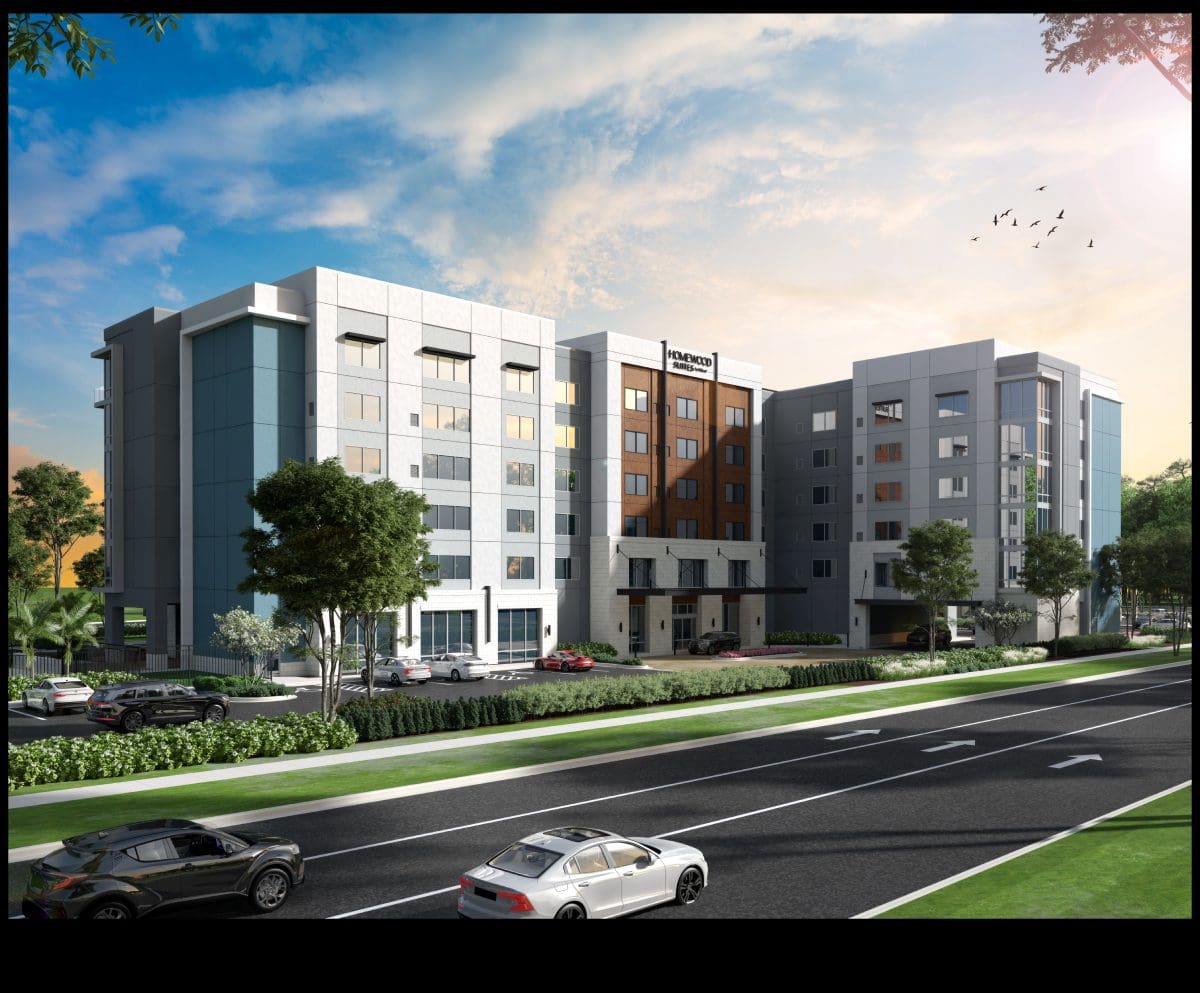 Modern hotel building with parked cars outside.