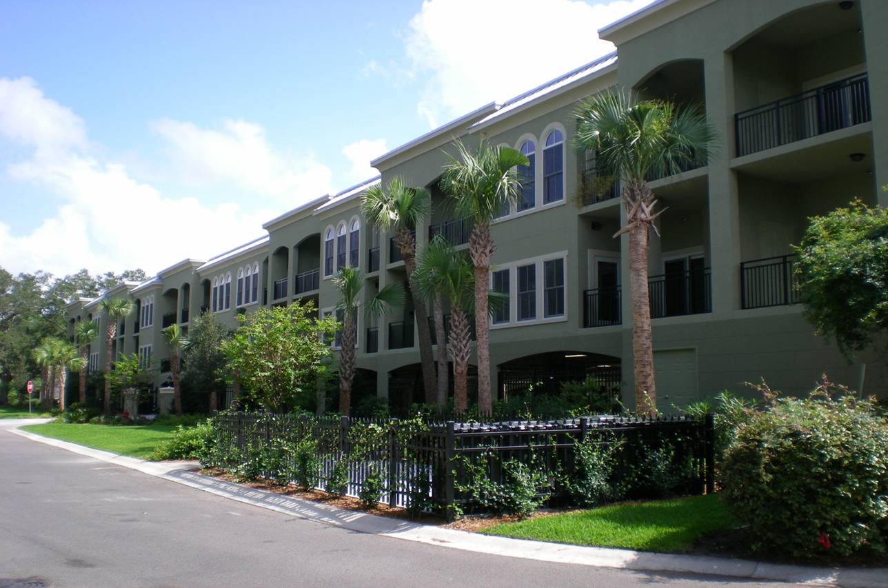 Apartment building with palm trees and balconies.