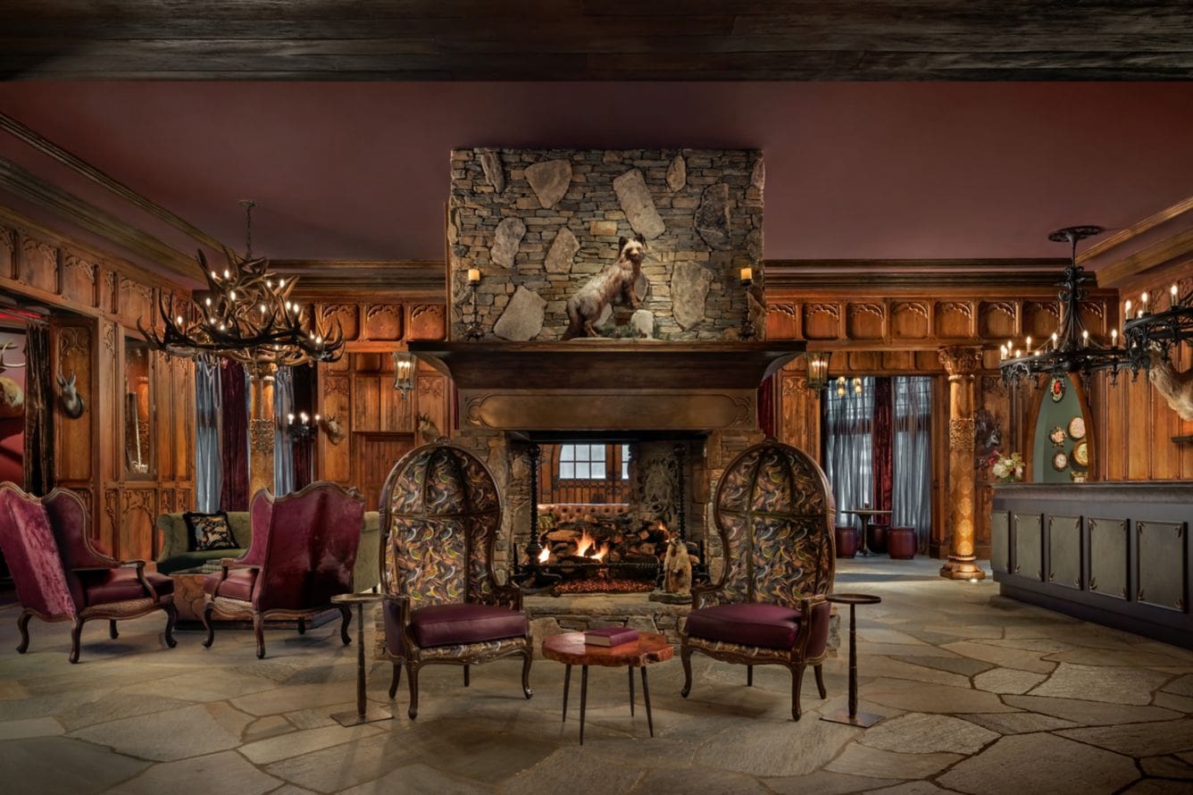 Rustic hotel lobby with stone fireplace.