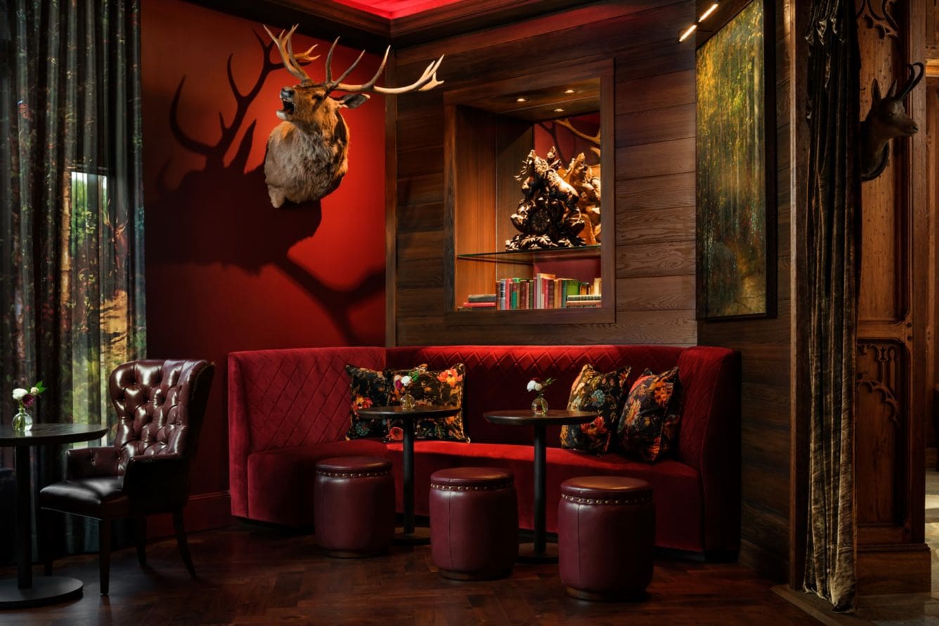 Cozy red lounge with deer head decor.