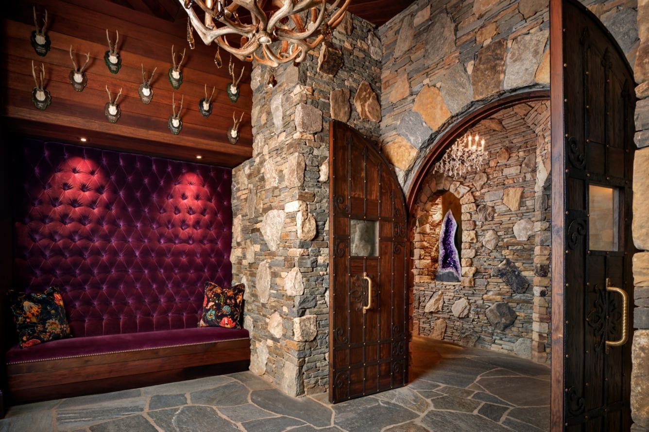 Stone hallway with purple seating and chandelier.