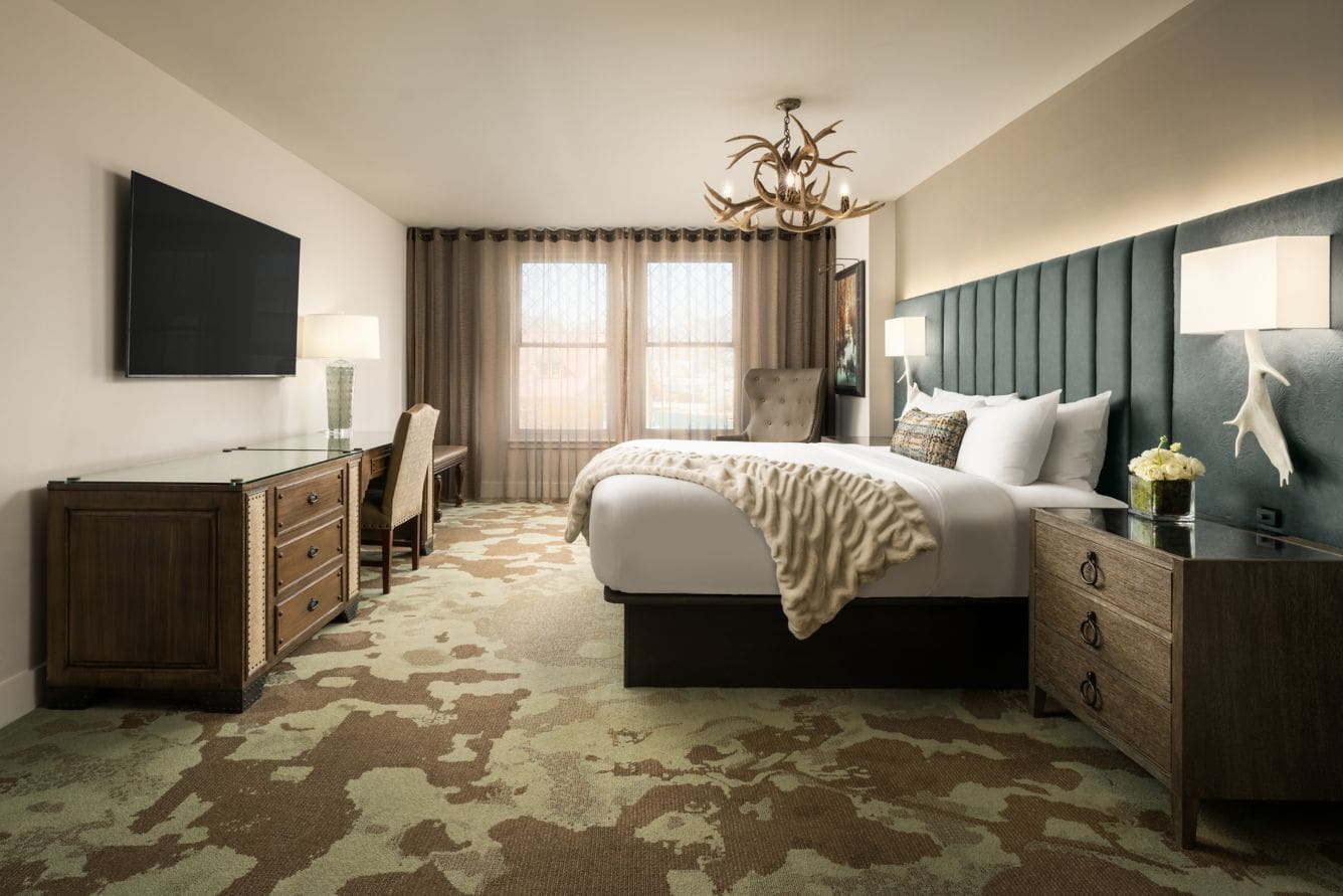 Hotel room with bed and decorative lighting.