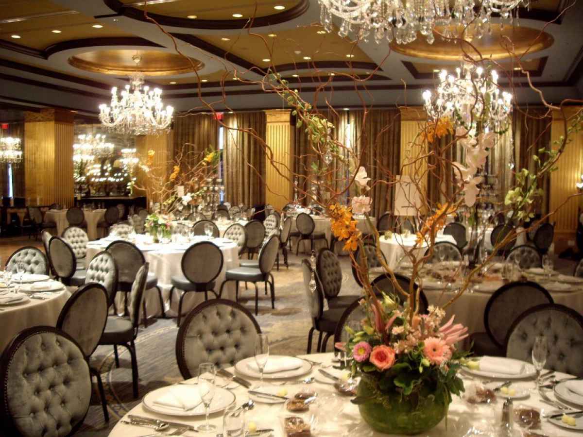 Elegant banquet hall with chandeliers and flowers.