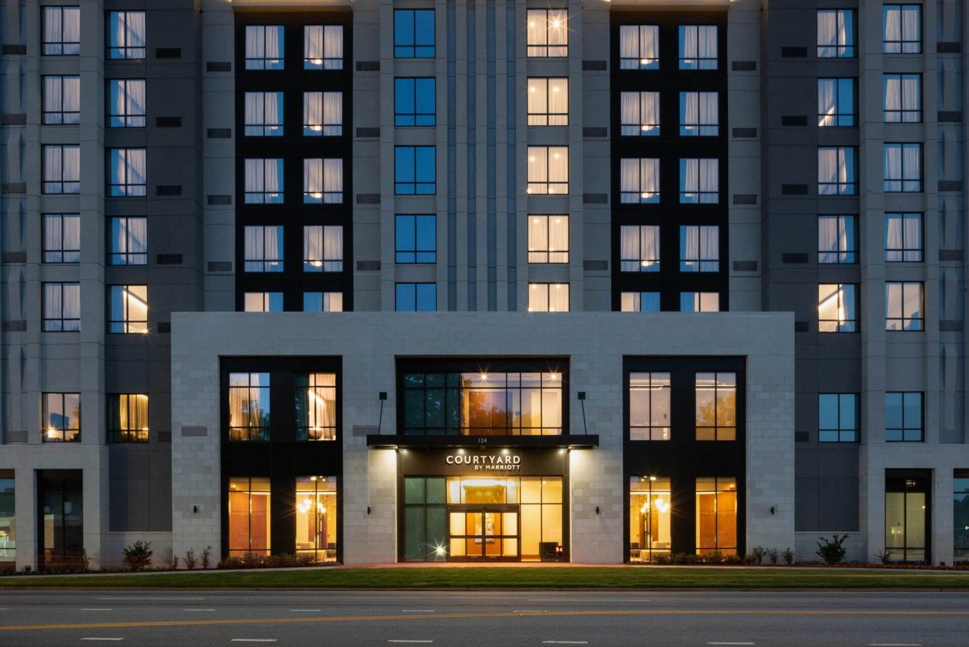 Modern hotel facade with illuminated windows at night.