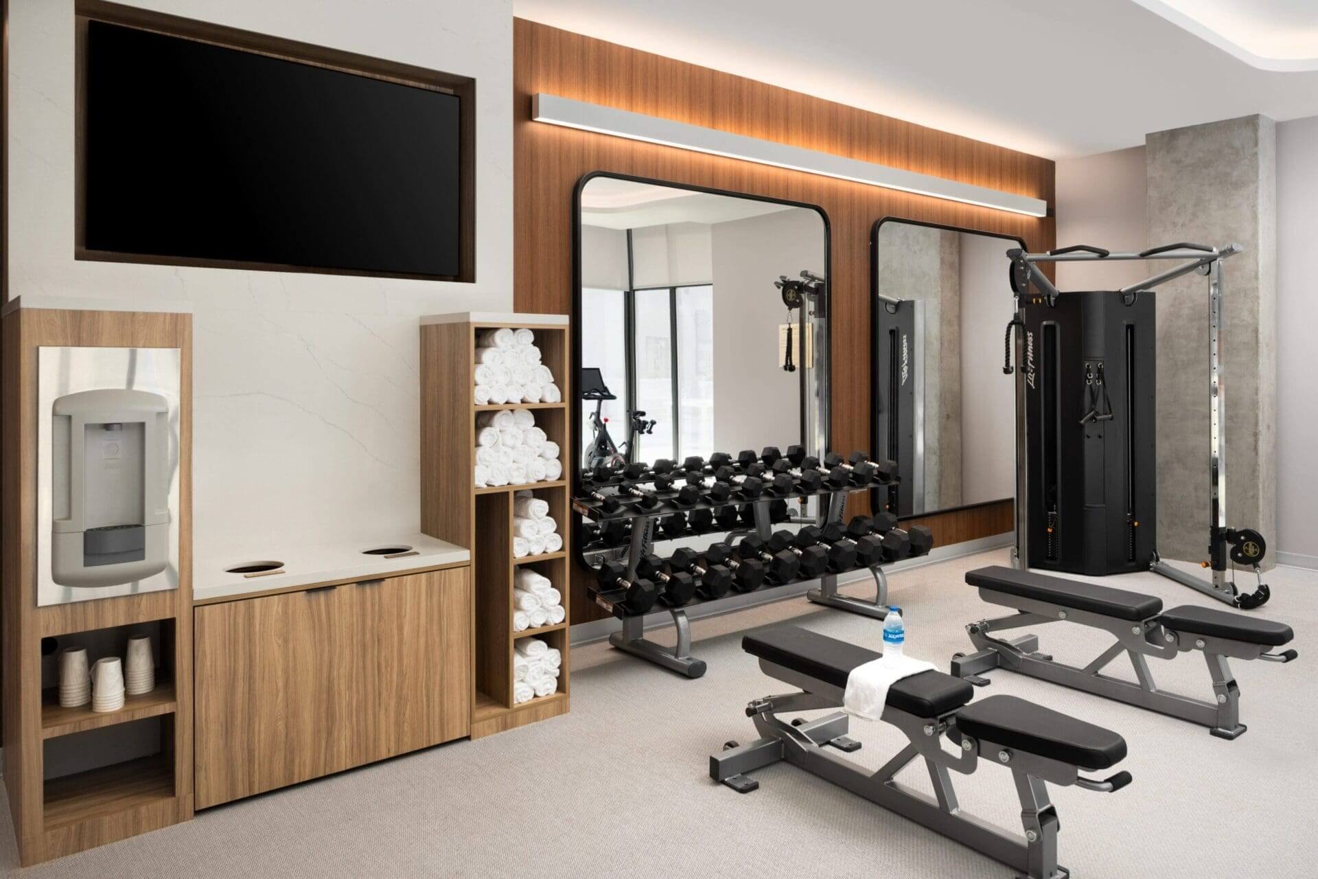 Modern gym with equipment and mirrors.