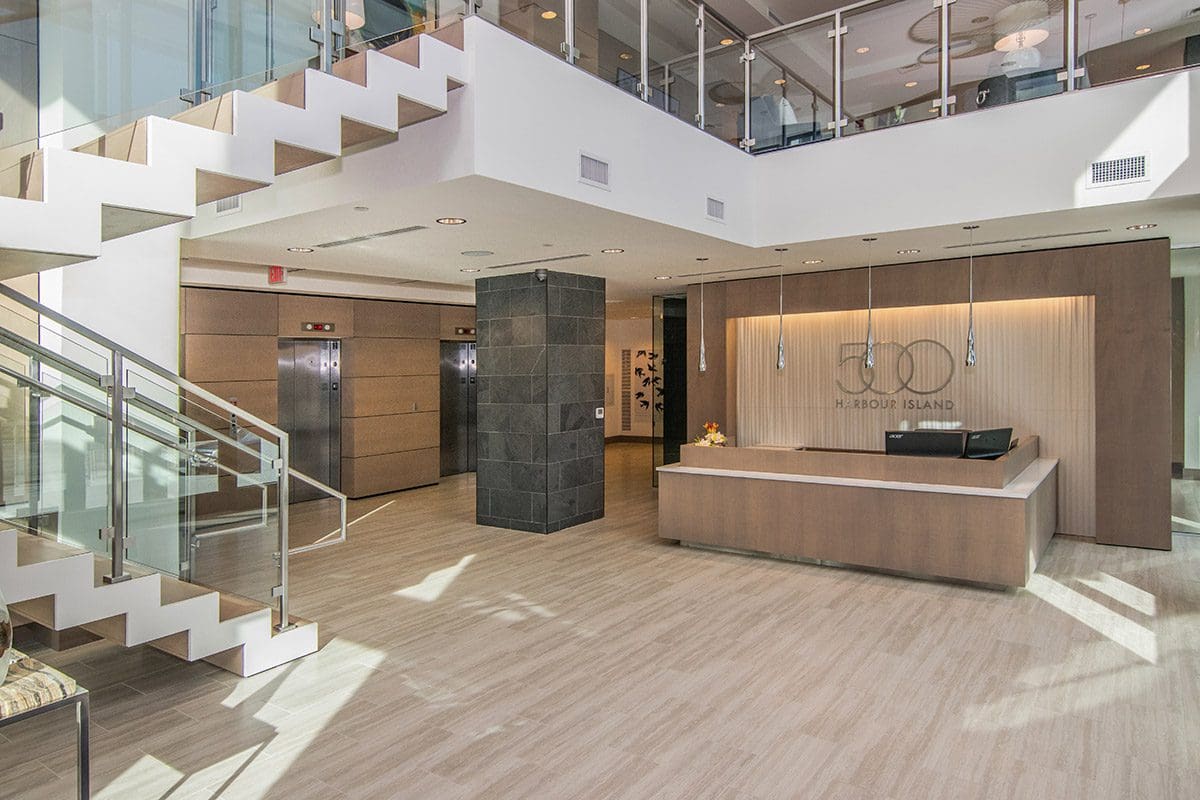 Modern office lobby with staircase and elevators.