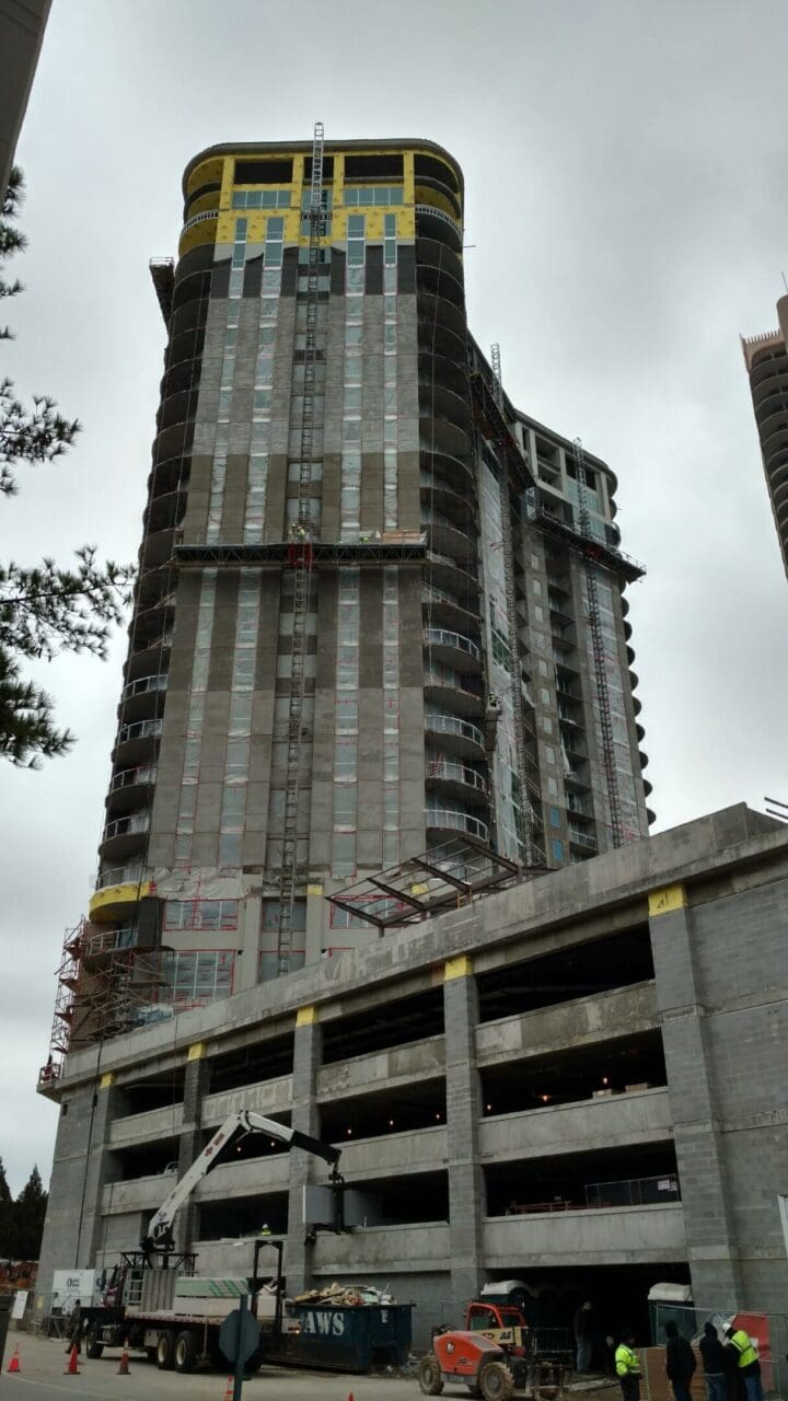 Skyscraper under construction with cloudy sky.
