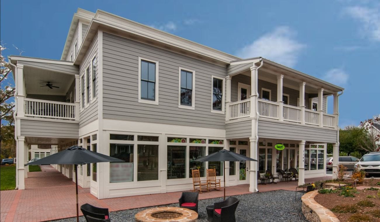 Modern two-story building with outdoor seating area.
