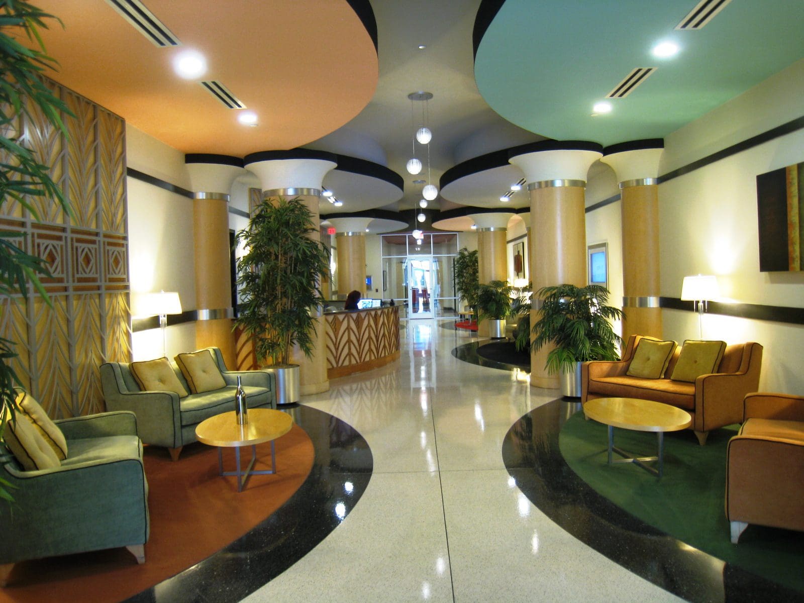 Modern hotel lobby with colorful ceiling design.