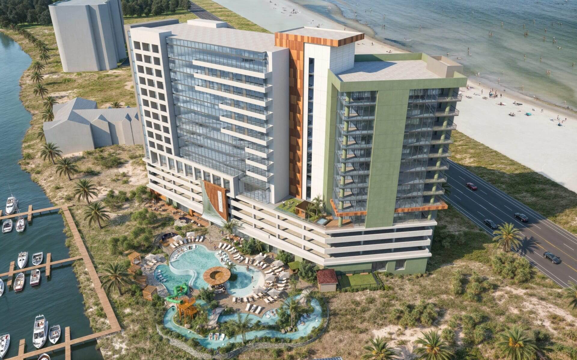 Beachfront hotel with pool and palm trees.