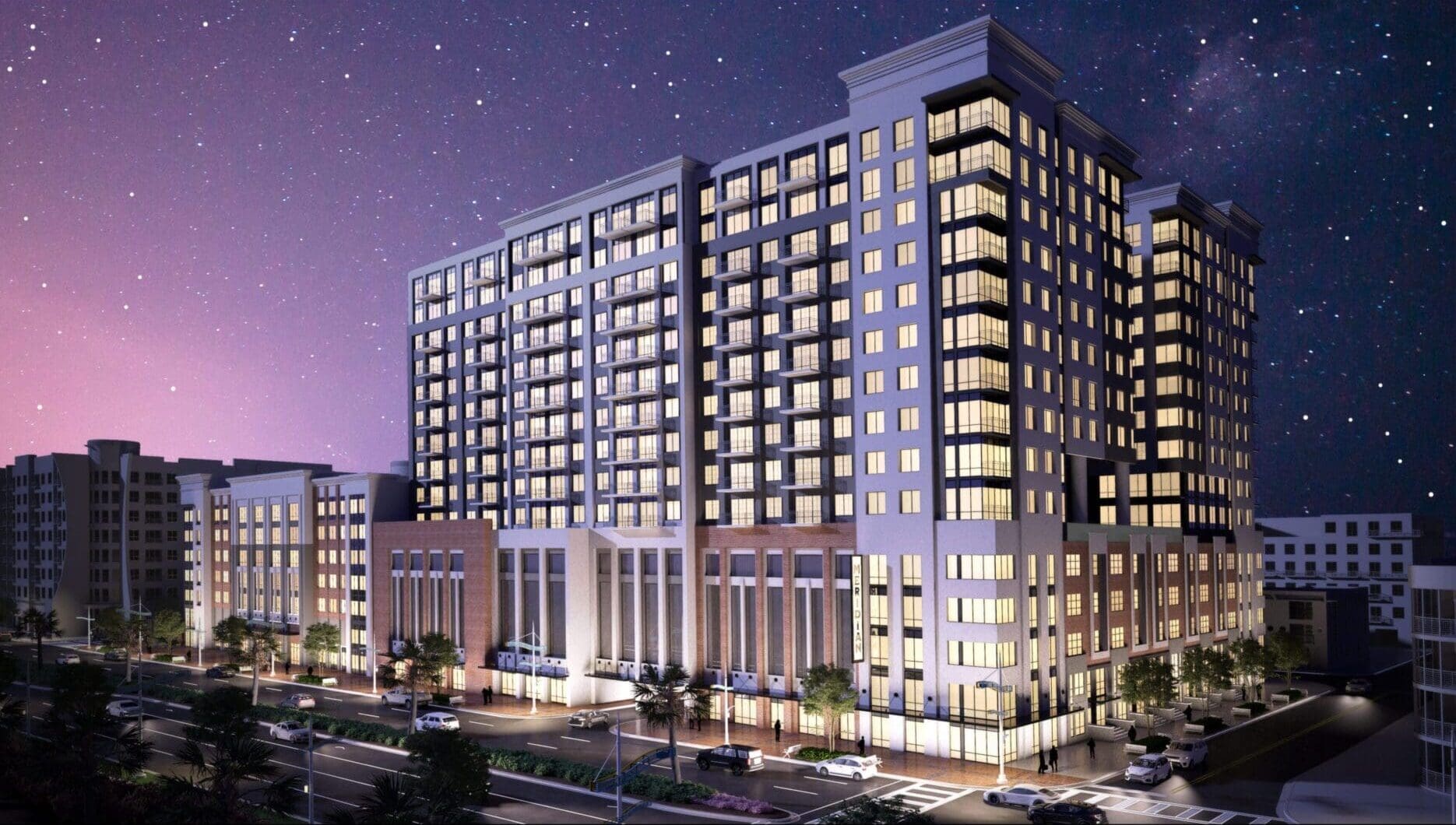 Modern multi-story apartment building illuminated at night.