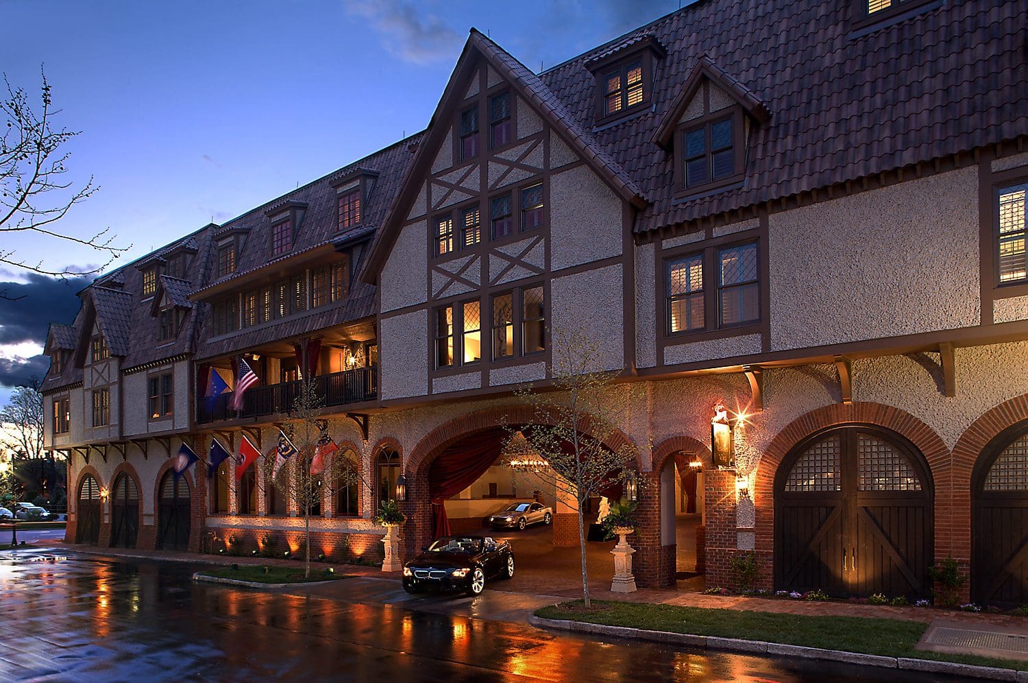 Cozy Tudor-style building illuminated at dusk with vintage street lamps.