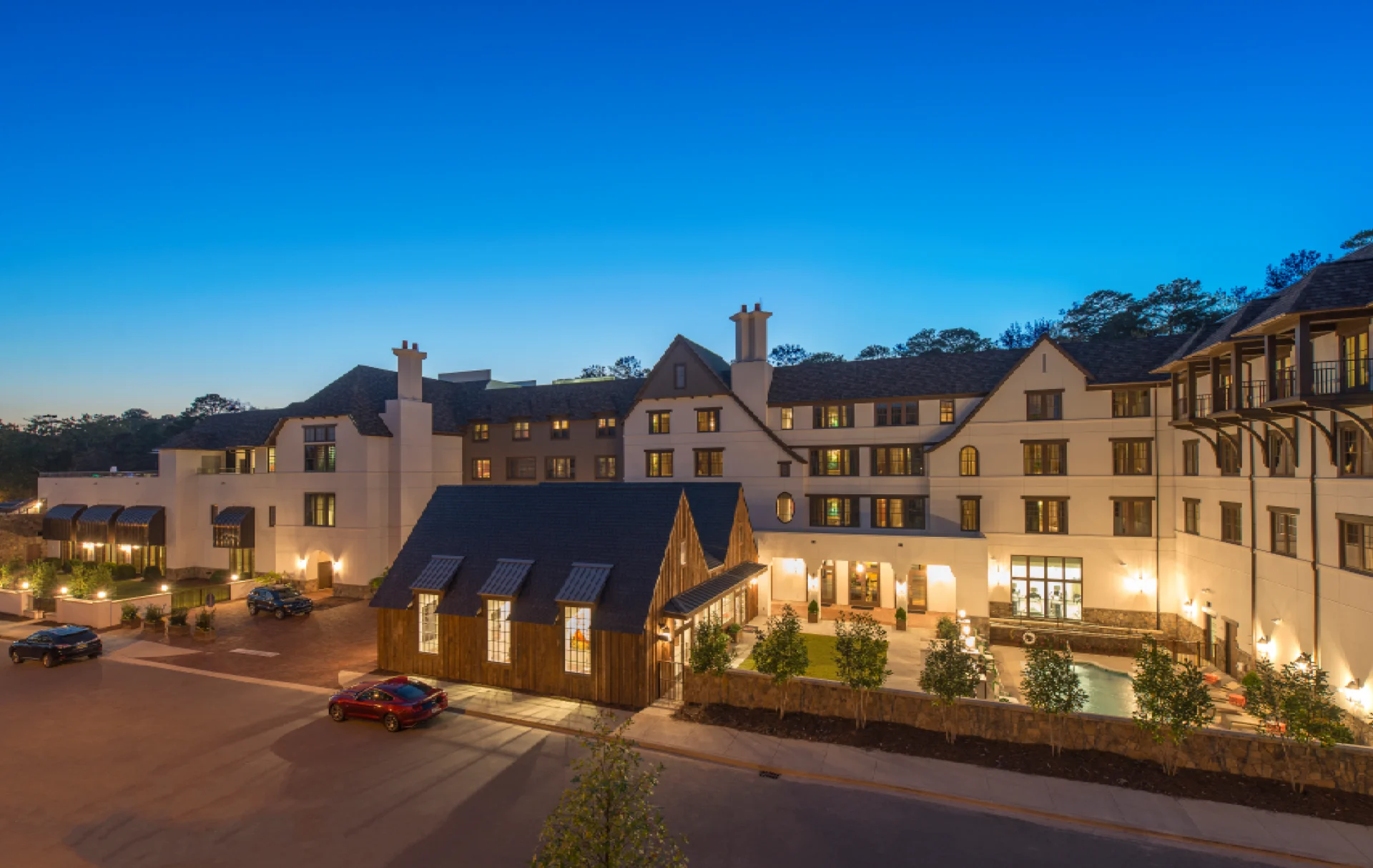 A charming building complex illuminated at dusk under a clear blue sky.