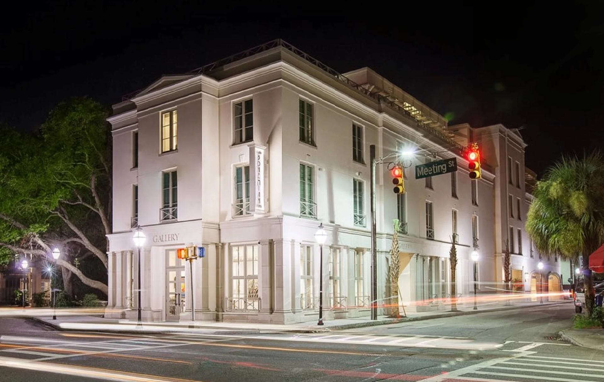 A three-story corner building illuminated at night with streetlights.