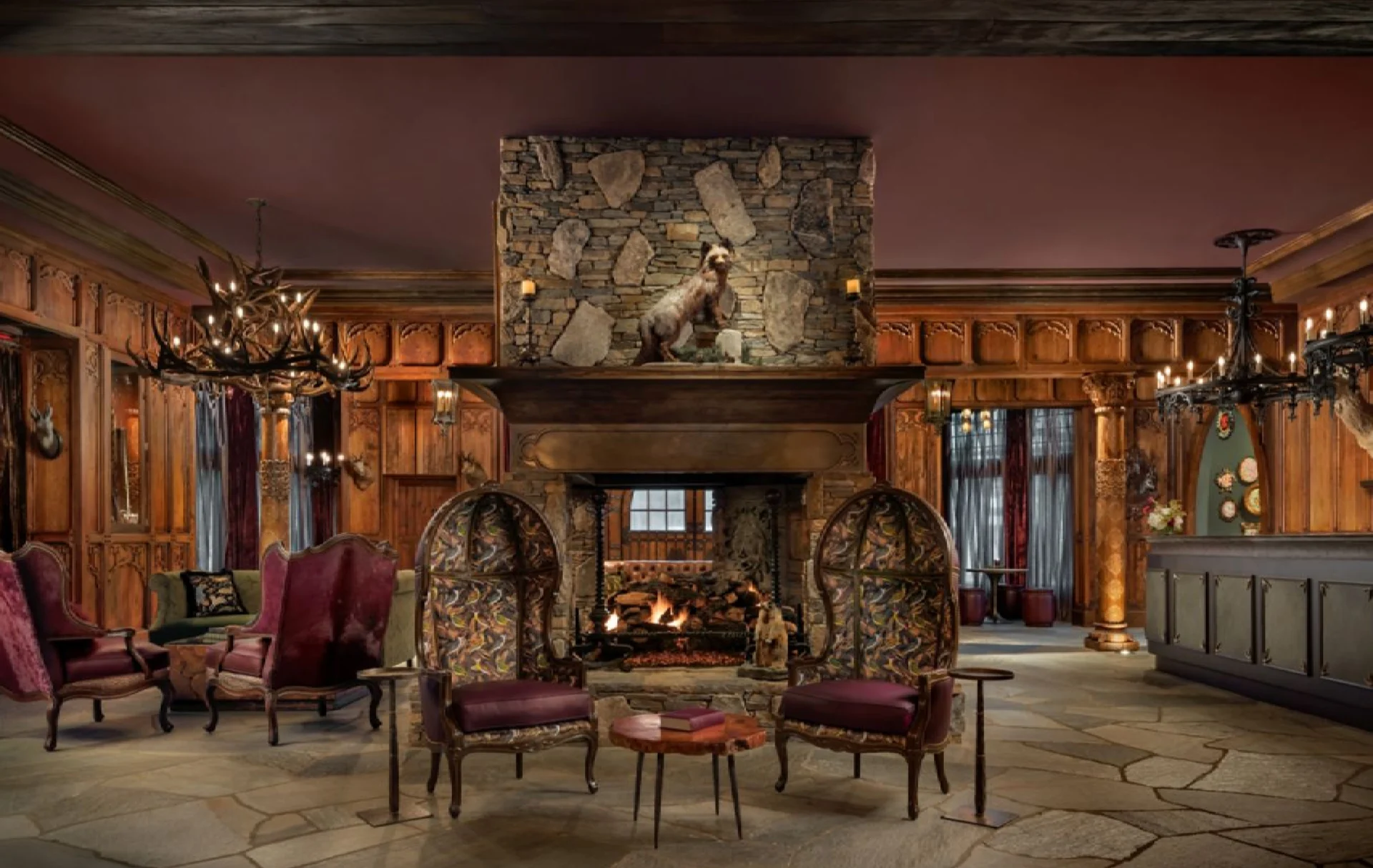 Cozy rustic living room with a stone fireplace and vintage chairs.