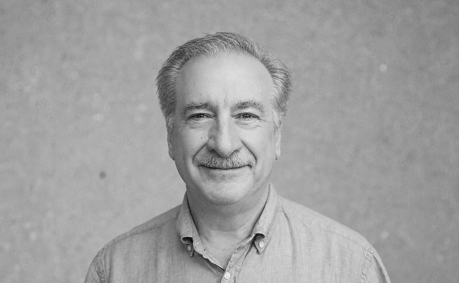 Black-and-white headshot of smiling man
