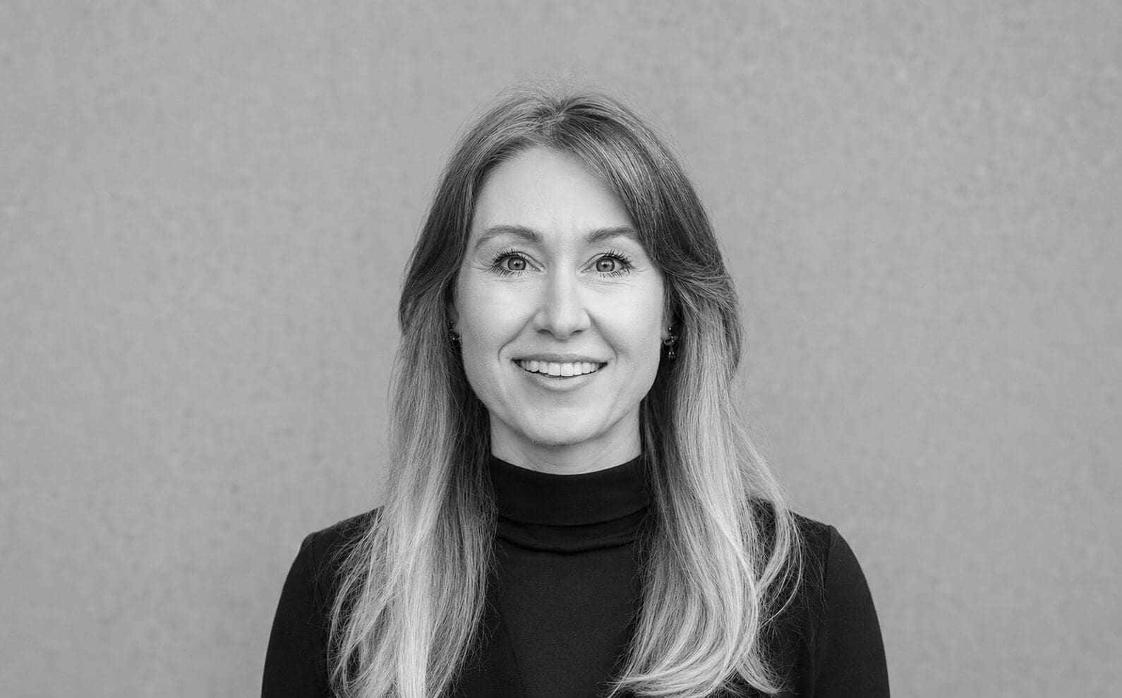 Smiling woman wearing black turtleneck